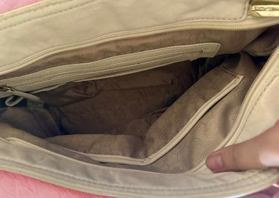 Interior view of a Michael Kors handbag bundle with multiple compartments for organization