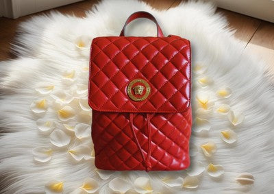 Versace red quilted backpack featuring a stylish design and luxurious finish on a soft floral backdrop